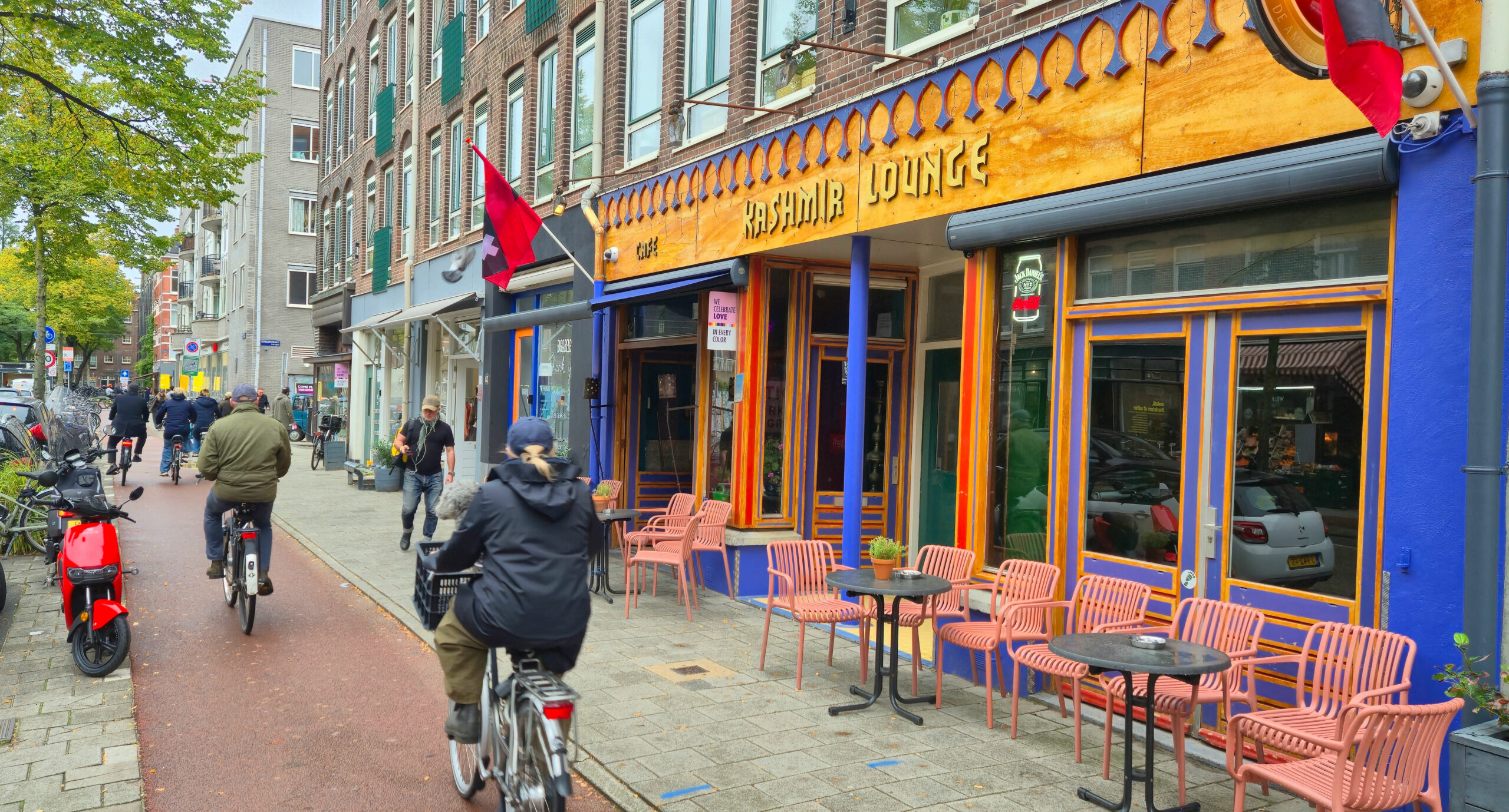 The Kashmir Lounge front on the Jan Pieter Heijestraat, with the terrace and Amsterdam flags
