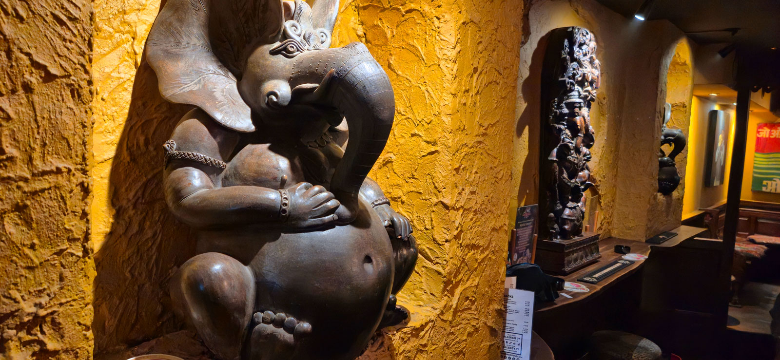 A large Ganesha statue against the yellow textured wall