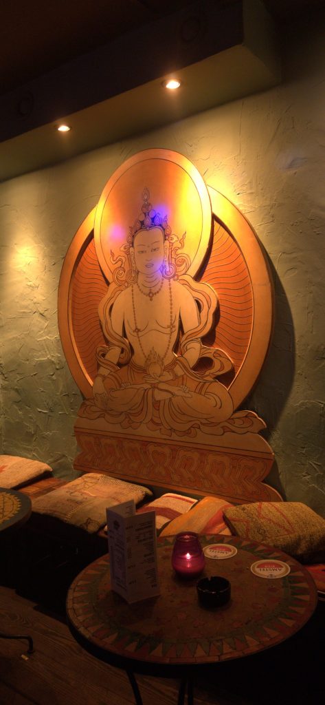 Golden Buddha carving above a lounge table with candles